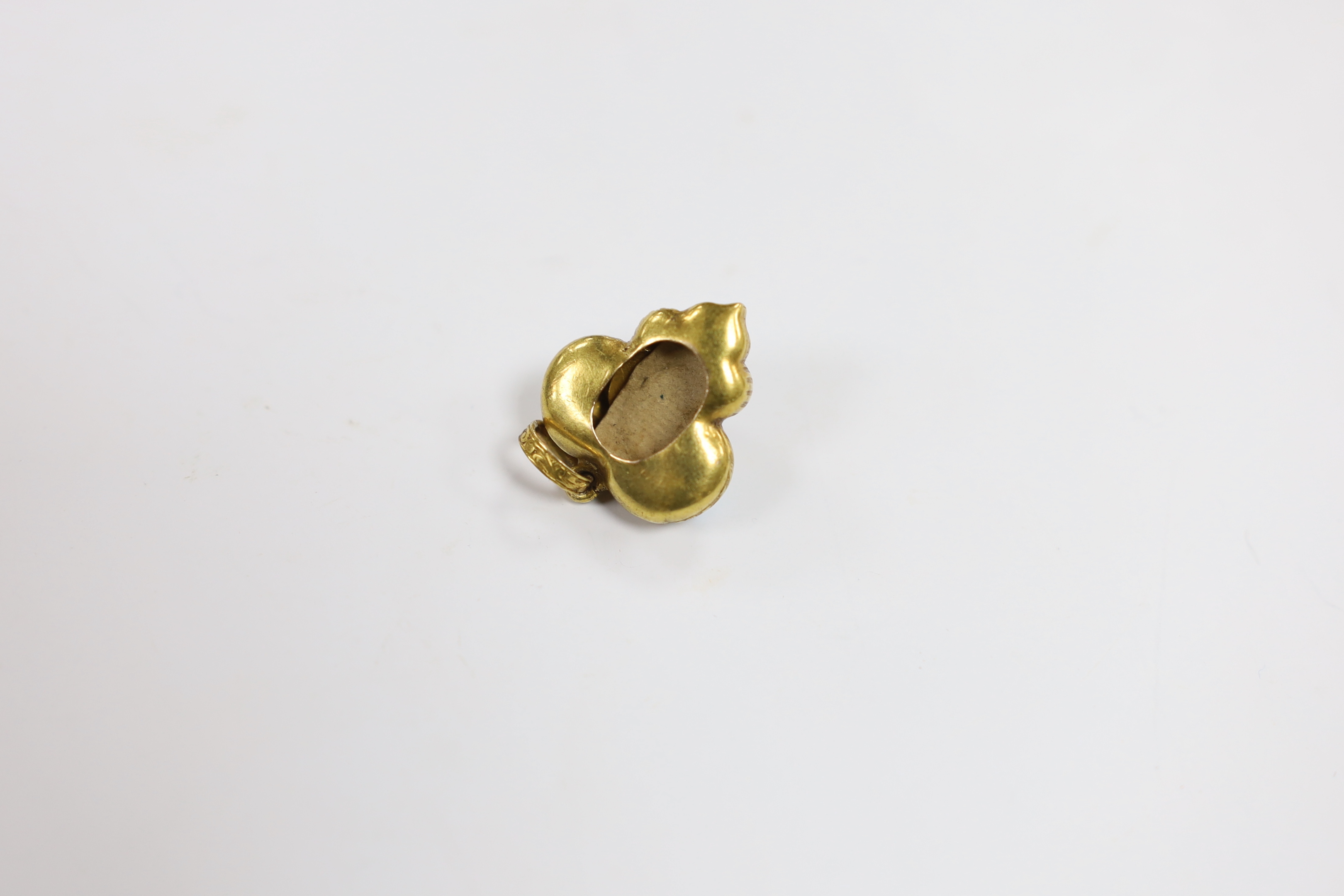 A Victorian yellow metal, blue enamel and garnet shaped triform pendant, overall 29mm, gross weight 4 grams.